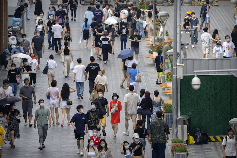ASSOCIATED PRESS / JULY 2
                                People wearing face masks walk along a pedestrian shopping street in Beijing.
