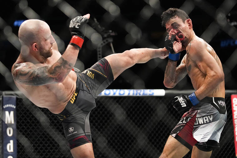 ASSOCIATED PRESS
                                Alexander Volkanovski, left, kicks Max Holloway in a featherweight title bout during the UFC 276 mixed martial arts event today.
