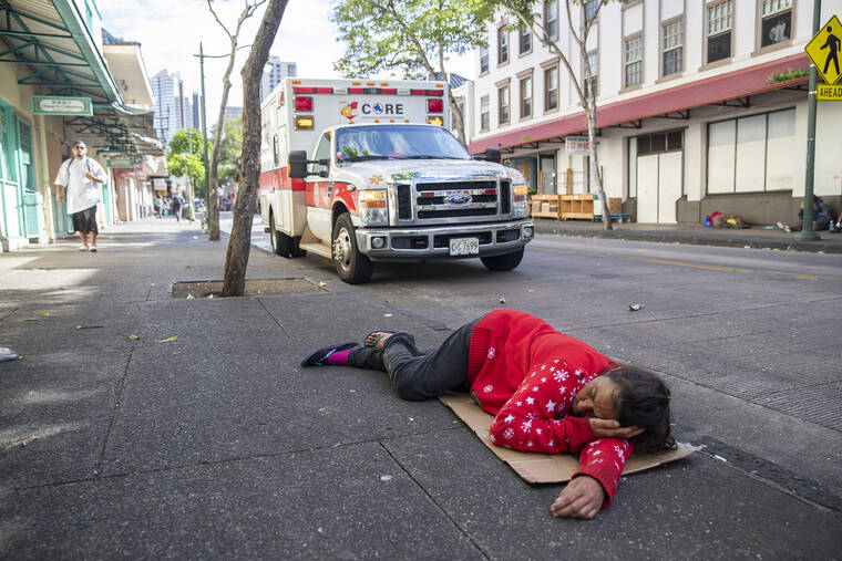 CINDY ELLEN RUSSELL / CRUSSELL@STARADVERTISER.COM
                                A woman sleeps on the sidewalk of North Hotel Street in Chinatown. Parked behind her is the Crisis Outreach Response and Engagement ambulance. The EMT team were out checking on homeless individuals as part of their service patrol on Dec. 9.