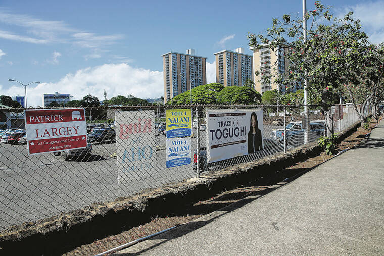 JAMM AQUINO / JULY 9
                                Political candidate signs line a fence along Pali Highway.