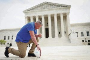 GETTY IMAGES / TRIBUNE NEWS SERVICE
                                Former high school assistant football coach Joseph Kennedy from Washington state took a knee in front of the U.S. Supreme Court after his legal case, Kennedy v. Bremerton School District, was argued in April in Washington, D.C.