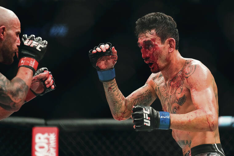 ASSOCIATED PRESS
                                Alexander Volkanovski, left, fights Max Holloway in a featherweight title bout during the UFC 276 mixed martial arts event Saturday.