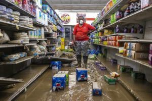 LEXINGTON HERALD-LEADER / AP
                                Gwen Christian stands in an aisle at the Isom IGA in Isom, Ky., on Monday, Aug. 1. Christian began working at the store as a cashier months after it first opened in 1973. She now owns the store with her husband, Arthur. Last week, historic floods ravaged the store.