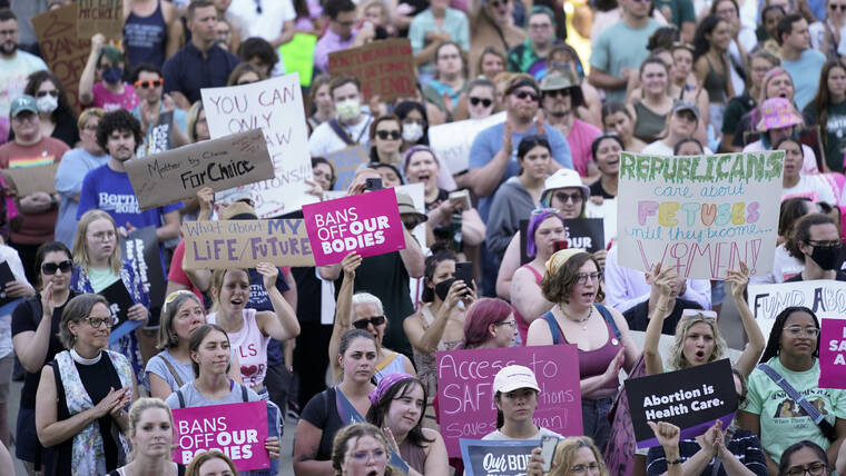 ASSOCIATED PRESS
                                Abortion rights protesters cheer at a rally outside the state capitol in Lansing, Mich., on June 24.
