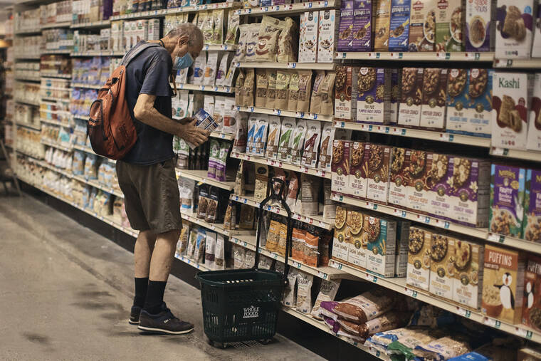 ASSOCIATED PRESS
                                A man shops at a supermarket, Wednesday, in New York. Whether the U.S. economy is heading for a recession got more difficult to answer today when a report showed employers hired hundreds of thousands more workers last month than expected.