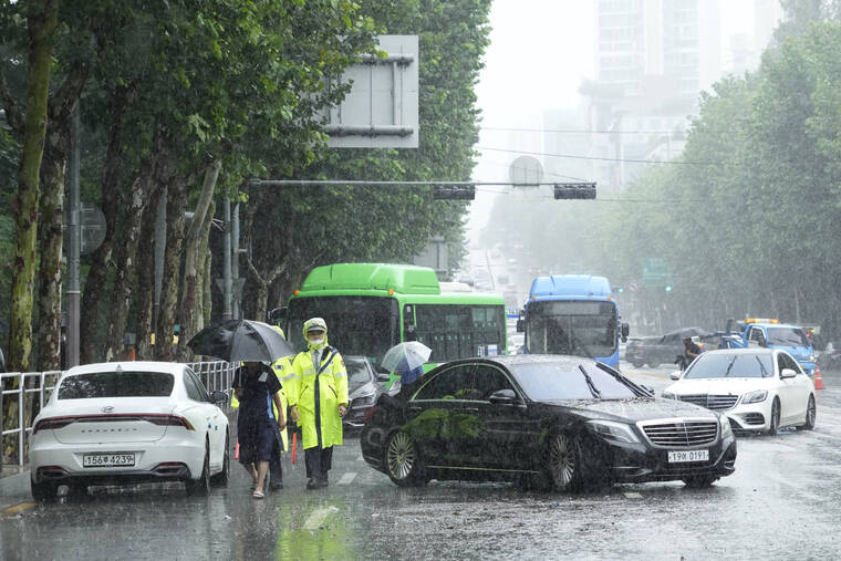 ASSOCIATED PRESS
                                Vehicles, which had been submerged by the heavy rainfall, block a road in Seoul, Tuesday. Heavy rains drenched South Korea’s capital region, turning the streets of Seoul’s affluent Gangnam district into a river, leaving submerged vehicles and overwhelming public transport systems.