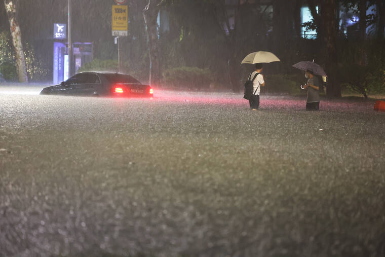 Hwang Kwang-mo/Yonhap via ASSOCIATED PRESS
                                A vehicle is submerged in a flooded road in Seoul, Monday. Heavy rains drenched South Korea’s capital region, turning the streets of Seoul’s affluent Gangnam district into a river, leaving submerged vehicles and overwhelming public transport systems.