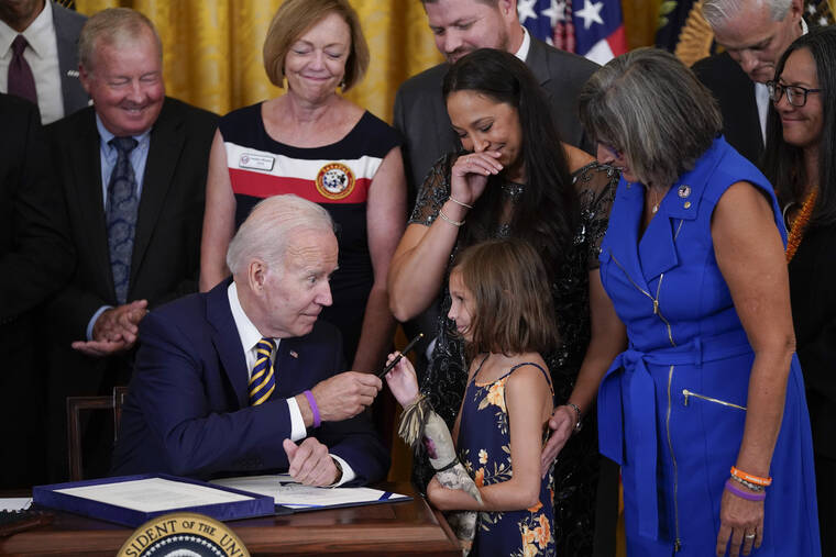 ASSOCIATED PRESS
                                President Joe Biden gives the pen he used to sign the “PACT Act of 2022” to Brielle Robinson, daughter of Sgt. 1st Class Heath Robinson, who died of cancer two years ago, during a ceremony in the East Room of the White House, today, in Washington.