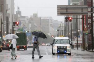 KYODO NEWS / AP
                                People walk in the rain in front of a station, Saturday, Aug. 13, in Shizuoka, west of Tokyo. Tropical Storm Meari is unleashing heavy rains on southwestern Japan as it heads northward toward the Tokyo capital, according to Japanese weather officials.