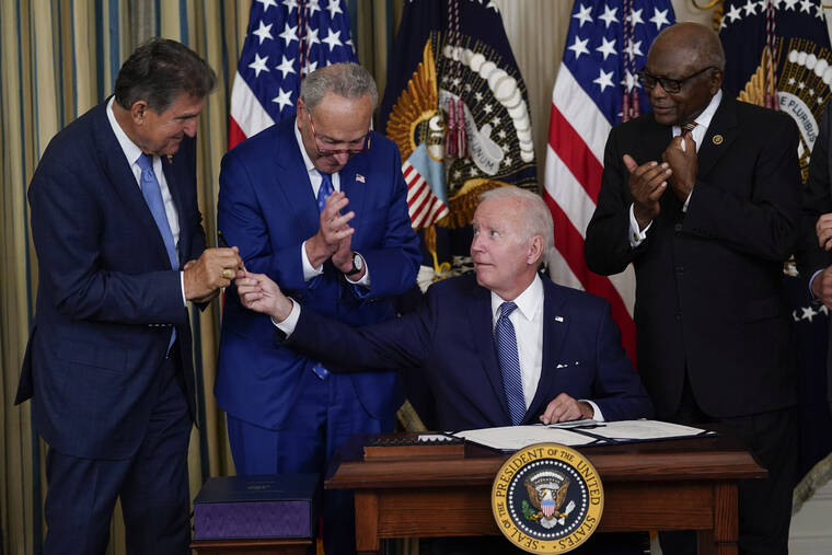 ASSOCIATED PRESS
                                President Joe Biden hands the pen he used to sign the Democrats’ landmark climate change and health care bill to Sen. Joe Manchin, D-W.Va., in the State Dining Room of the White House in Washington, today.
