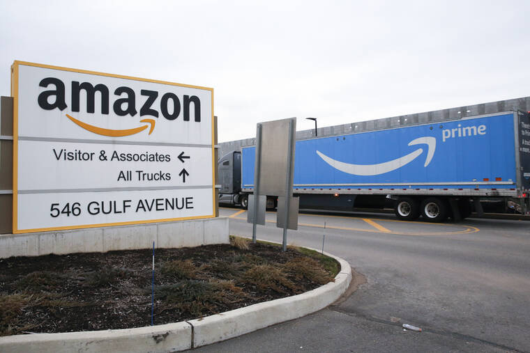 ASSOCIATED PRESS / 2020
                                An Amazon Prime truck passes by a sign outside an Amazon fulfillment center on the Staten Island borough of New York. Amazon is raising charges on third-party sellers again — this time adding a holiday fee for merchants who use the company’s fulfillment services to pack and ship items to customer, according to a notice the company sent to merchants on Tuesday, Aug. 16.