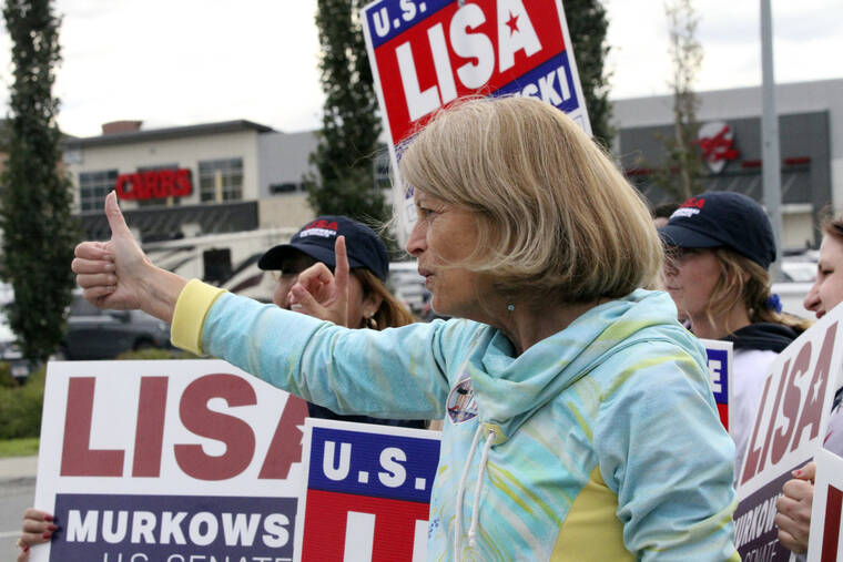 ASSOCIATED PRESS
                                U.S. Sen. Lisa Murkowski, an Alaska Republican, flashes a thumbs-up to a passing motorist while waving signs today in Anchorage, Alaska.