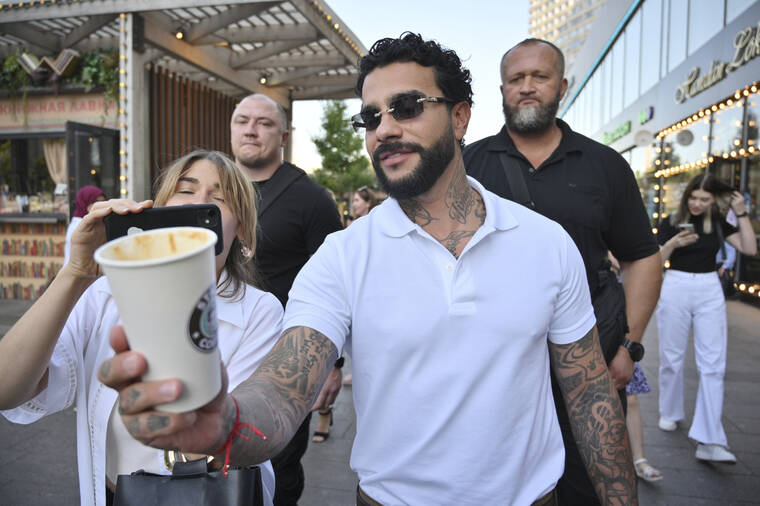 DMITRY SEREBRYAKOV / AP
                                Russian singer and entrepreneur Timur Yunusov, better known as Timati, poses in front of a newly opened Stars Coffee coffee shop in the former location of the Starbucks coffee shop in Moscow, Russia, Thursday, Aug. 18.
