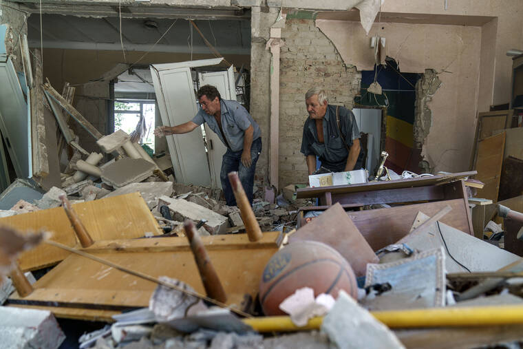 DAVID GOLDMAN / AP
                                Viktor Bielkin, left, and Anatolii Slobodianik, sift through the rubble of the Kramatorsk College of Technologies and Design, where they’re maintenance workers, after it was hit in an early morning rocket attack in Kramatorsk, Donetsk region, eastern Ukraine, Friday, Aug. 19.