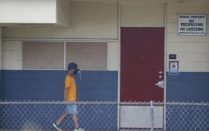 JAMM AQUINO/JAQUINO@STARADVERTISER.COM
                                A student wearing a mask walks the halls at Queen Kaahumanu Elementary School.