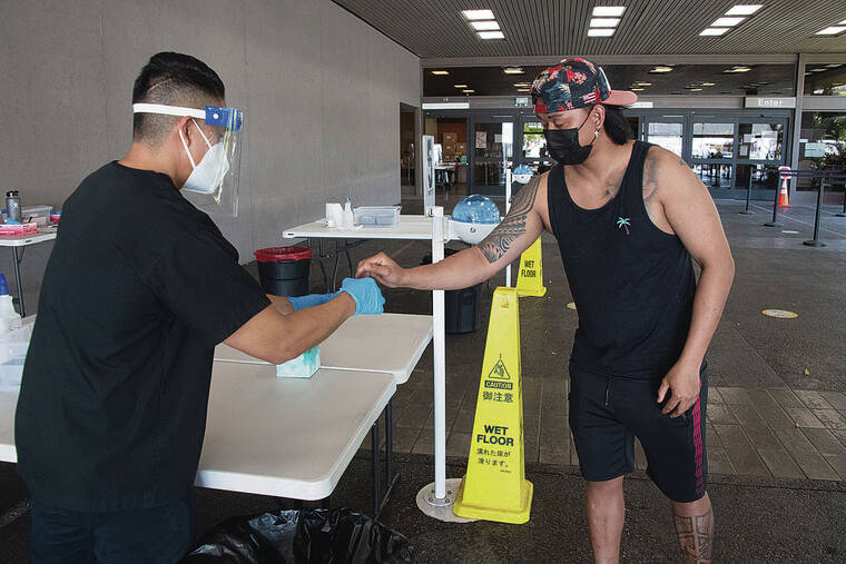 CRAIG T. KOJIMA / CKOJIMA@STARADVERTISER.COM
                                Chris Ramos, left, gave a swab to a client for COVID-19 testing Wednesday at Daniel K. Inouye International Airport. Testing is available daily from 9 a.m. to 5 p.m.