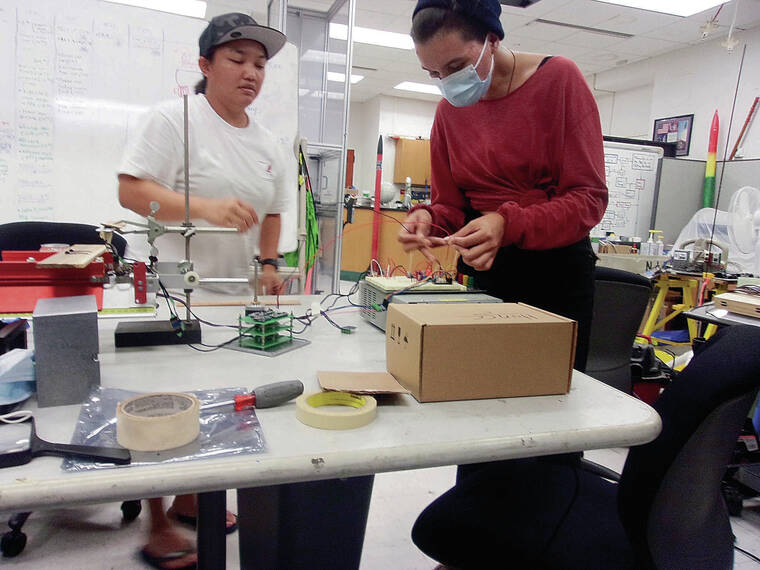 COURTESY UNIVERSITY OF HAWAII
                                Windward Community College students Nikki Arakawa, left, and D’Elle Martin work on a camphor- powered sublimation rocket.