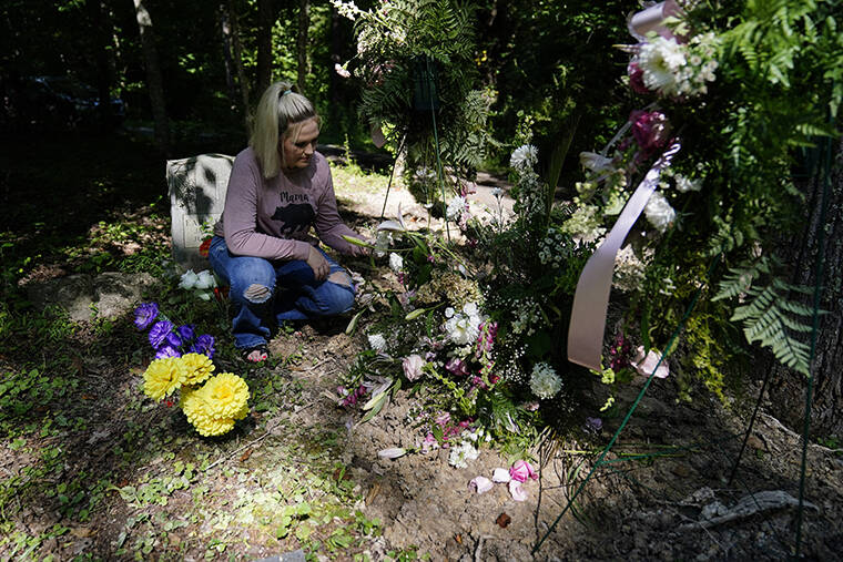 ASSOCIATED PRESS / AUG. 4
                                Angel Campbell, 37, visits the grave of her grandmother, Nellie Mae Howard, 82, on Thursday, Aug. 4, in Chavies, Ky. Howard died in massive flooding.