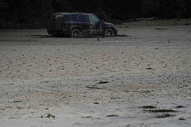 BRYNN ANDERSON / AP
                                A vehicle is abandoned and surrounded by mud caused by massive flooding on Friday, near Haddix, Ky.