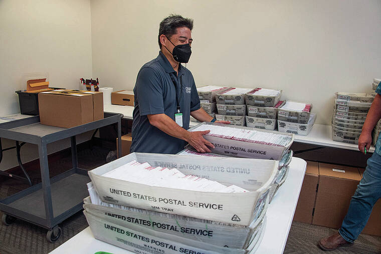 CRAIG T. KOJIMA / CKOJIMA@STARADVERTISER.COM
                                Scott Nago, chief elections officer for the state Office of Elections, stacked trays of ballot envelopes Wednesday, the first full day of ballot counting in the Capitol’s Senate chambers.