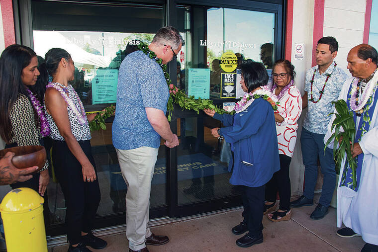 CRAIG T. KOJIMA / CKOJIMA@STARADVERTISER.COM
                                At top, Chris Smith, general manager of Western Division Fresenius Kidney Care, center left, and clinical manager Rhory Archibald, center right, untied maile lei Tuesday during a blessing at its new center in Nanakuli.