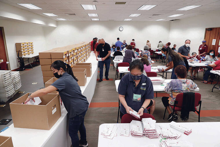 JAMM AQUINO / JAQUINO@STARADVERTISER.COM 
                                Over 234,000 ballots had been received via mail as of Wednesday. Volunteer Marcelle Mau, front right, sorted ballots Thursday at the state Capitol.