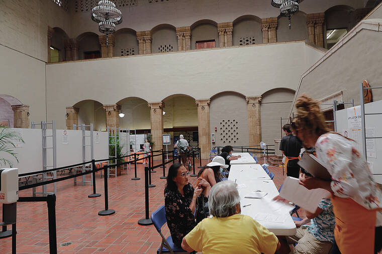JAMM AQUINO / JAQUINO@STARADVERTISER.COM
                                The 2022 Hawaii primary election officially takes place today, but voters have been casting ballots by mail and other means for more than two weeks. Above, voters registered before voting Friday at Honolulu Hale.