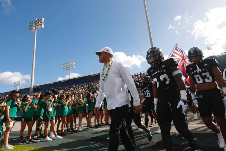 JAMM AQUINO / JAQUINO@STARADVERTISER.COM Timmy Chang leads the University of Hawaii football team out on the field for his debut as head coach against Vanderbilt at Clarence T.C. Ching Athletic Complex.