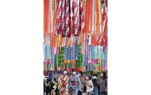 JAPAN NEWS-YOMIURI / JULY 28
                                <strong>Festive stroll: </strong>People walk beneath colorful streamers displayed for the annual Ichinomiya Tanabata Festival in Ichinomiya, Aichi prefecture. Though the fest was scaled back due to the pandemic, for the first time in three years the bon odori dance performance took place alongside the festival.
