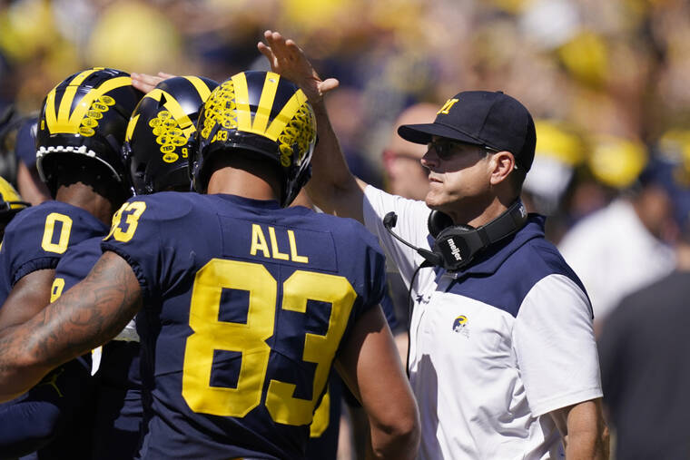 ASSOCIATED PRESS Michigan head coach Jim Harbaugh congratulates his players after a touchdown on Saturday.