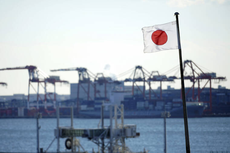 ASSOCIATED PRESS / JAN. 20 A national flag flies near a container port on Jan. 20, in Tokyo.