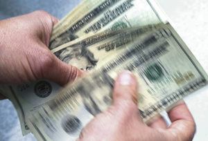 ASSOCIATED PRESS
                                Twenty dollar bills are counted in North Andover, Mass.