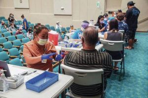 CRAIG T. KOJIMA/CKOJIMA@STARADVERTISER.COM
                                Kayla Ishinaga-Naito, PPA, administers shot to Don Figueira. The Queen’s Health System hosted a flu and COVID-19 vaccination event for the community.