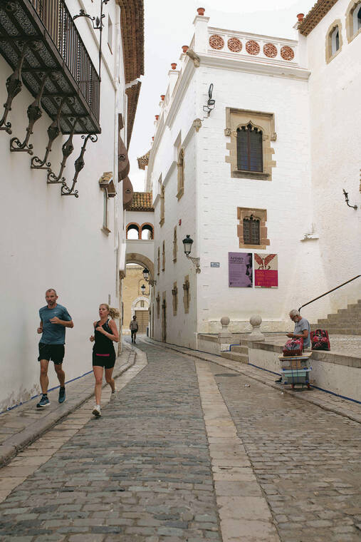 NEW YORK TIMES
                                Joggers run down the Carrer de Fonollar in Sitges, Spain.