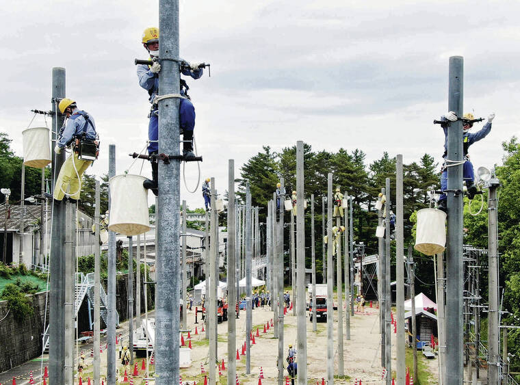 JAPAN NEWS-YOMIURI
                                <strong>POWER </strong><strong>TRAINING</strong>: Kansai Electric Power Co. workers scale 33-foot mock utility poles at a training facility in Ibaraki, Osaka prefecture, Japan. Since joining the company in the spring, the 57 new employees have learned how to work in settings high off the ground while carrying out tasks related to the distribution of electric power. The employees will train through next August before being assigned to work in different locations.