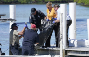 STEVE HELBER / AP
                                Rescue personnel lift a body recovered from Sanibel Island to a dock for transport to the medical examiner Saturday, Oct. 1, in Fort Myers, Fla.