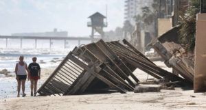 ORLANDO SENTINEL VIA AP
                                Beachgoers survey the damage today in Daytona Beach Shores, Fla., as hotel and condo seawalls and pool decks along the Volusia County coastline were gutted by Hurricane Ian last week.