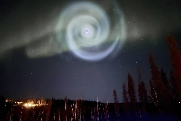 アラスカの夜空にオーロラの中に奇妙な螺旋が現れる