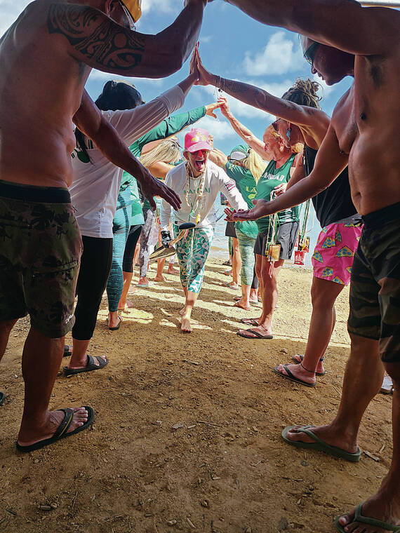 KYLE GALDEIRA / SPECIAL TO THE STAR-ADVERTISER
                                Sharon Esser made her way through Lanikais victory tunnel after helping the womens masters 65 crew race to victory at the Oahu Hawaiian Canoe Racing Association Championship regatta held Sunday at Keehi Lagoon.